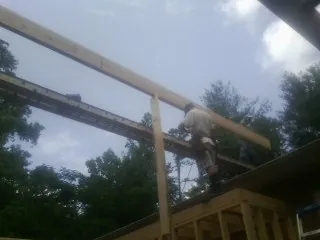 Carpenter setting a ridge beam over a new addition frame — Ice Dam Removal by Roofing Brothers in Brooklet